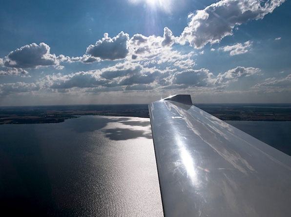 Luftaufnahme aus Flugzeug mit Tragfläche und Wolken